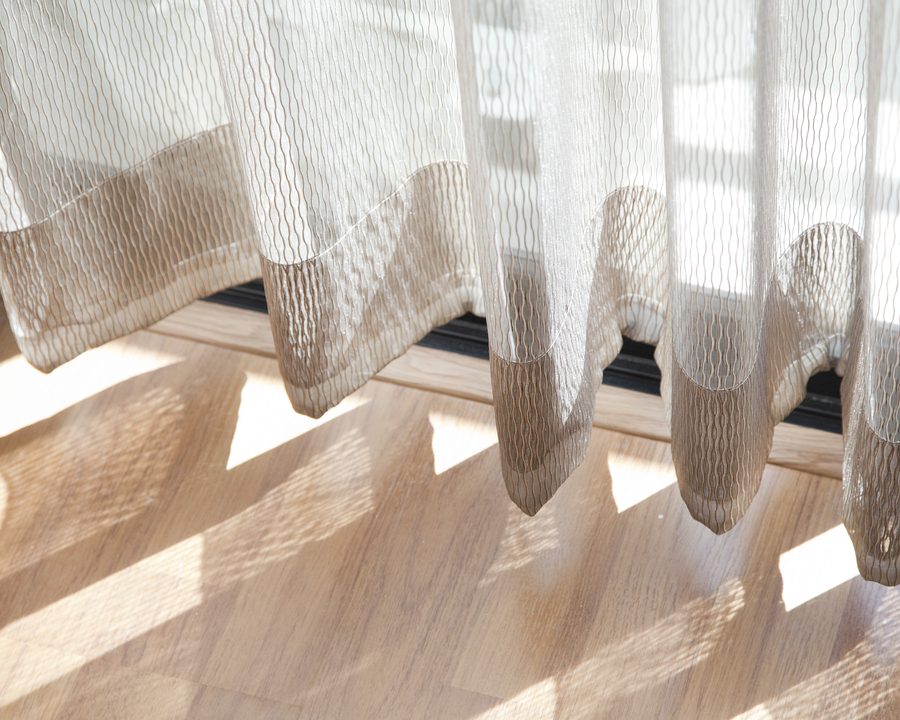 Sheer curtain diffusing direct sunlight into soft daylight